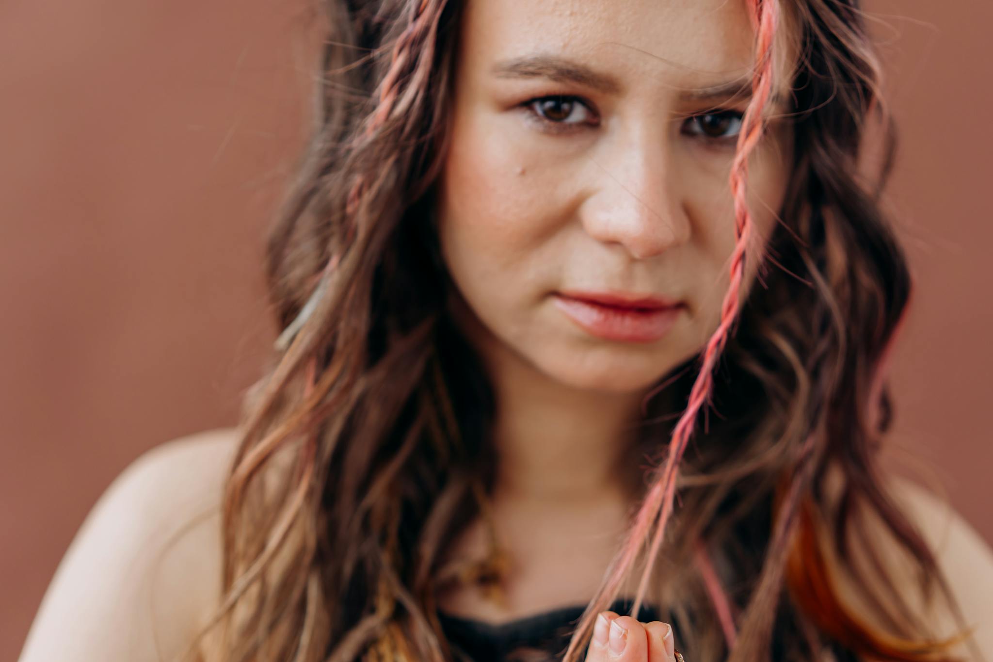 Close-up of a woman with braided hair meditating with a peaceful expression.